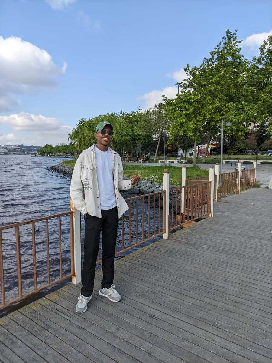 Ahmed Eltigani smiling on a waterfront boardwalk